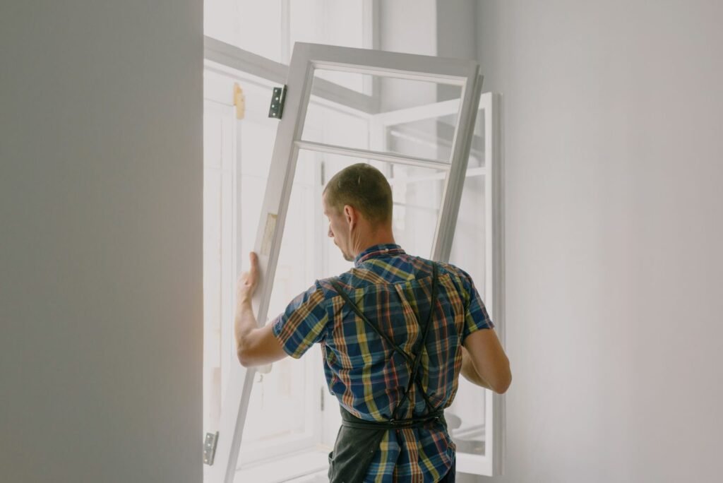 Menuisier installant une fenêtre pendant une rénovation