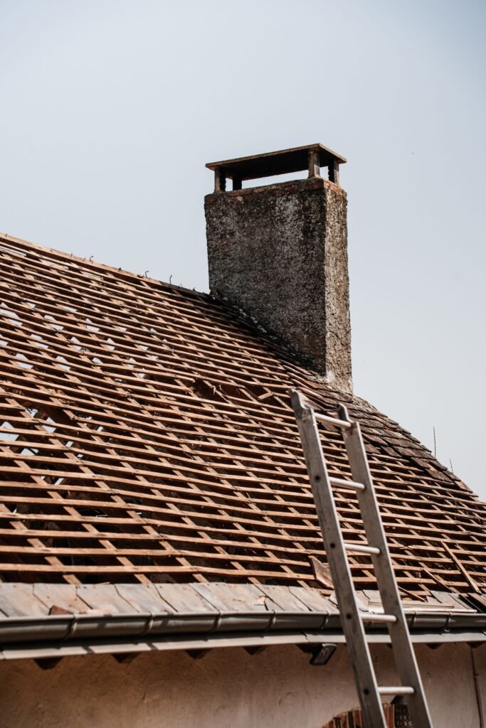 Rénovation de toiture avec cheminée et échelle